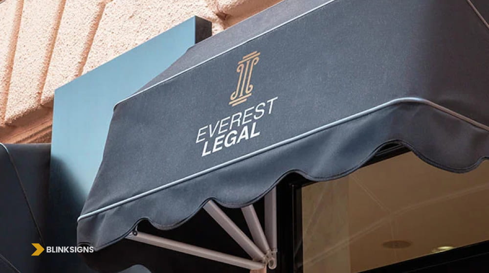 Custom black fabric commercial dome awning sign with gold logo for Everest Legal law office.