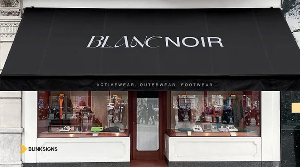 Modern black shed-style storefront awning sign with white lettering for Blanc Noir boutique.