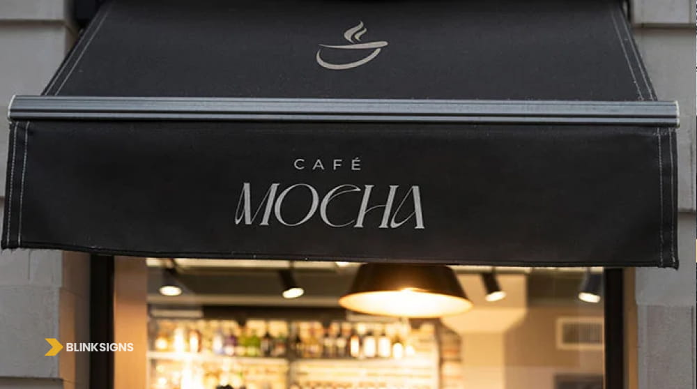 Black retractable storefront awning with white coffee cup logo and lettering for Café Mocha.
